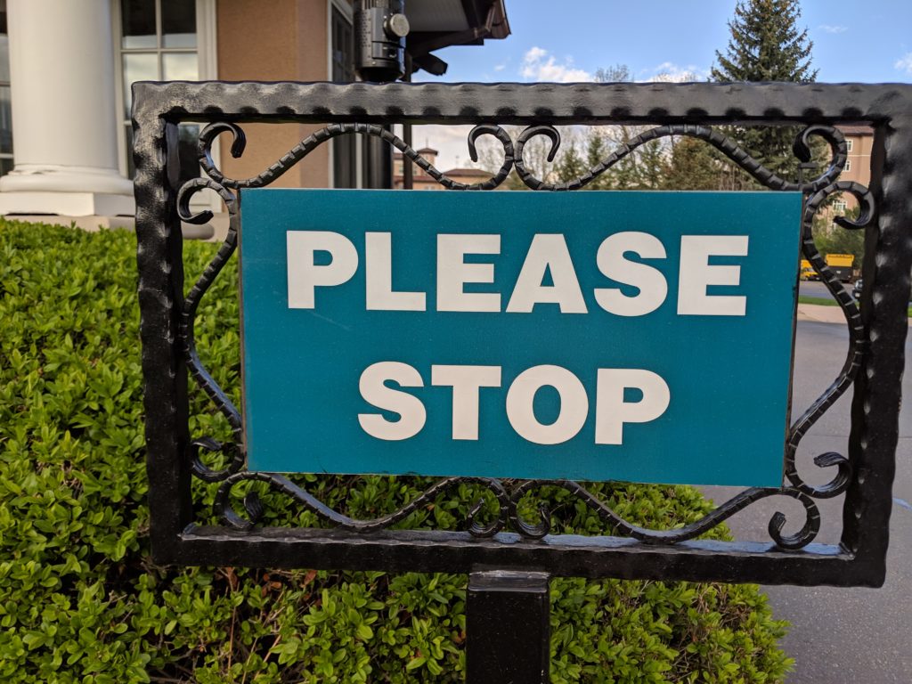 Photo of a sign that reads "Please stop"